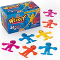 Seven smiley stretchy man party favors in four bright colors arranged in front of their blue gift box