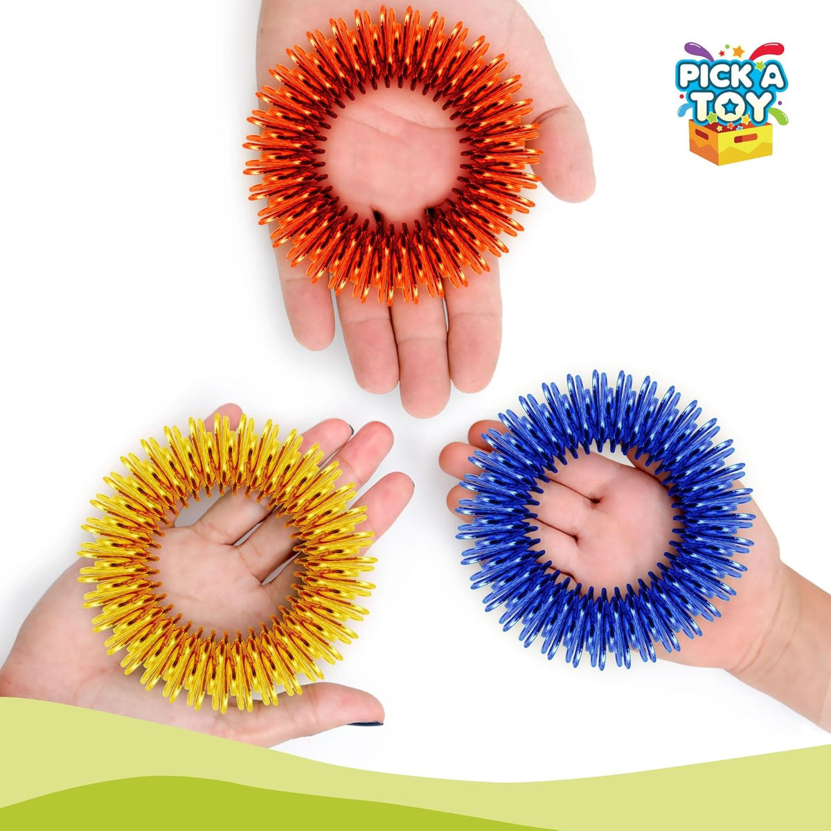 Three open hands each holding a spiky metal sensory bracelet in orange, yellow and blue on a white background